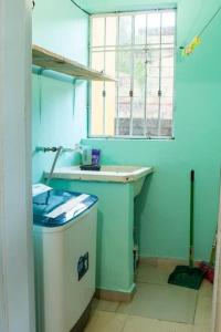 baño pequeño con lavabo y ventana en Confortable apartamento- Cotuí, en Cotuí