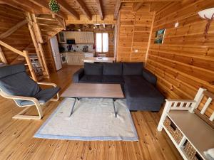 a living room with a couch and a table at Chalet bois au coeur des Pyrénées ariégeoises in LʼHospitalet-près-lʼAndorre