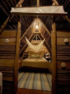 ein Schlafzimmer mit einem Bett in einem strohgedeckten Zimmer in der Unterkunft Chowa lodge in Nuquí