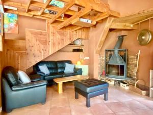 ein Wohnzimmer mit Ledermöbeln und einem Kamin in der Unterkunft Maison d'architecte en bois lac au bord du lac Salagou in Celles
