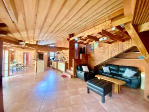 ein Wohnzimmer mit Sofas und einer Treppe in der Unterkunft Maison d'architecte en bois lac au bord du lac Salagou in Celles