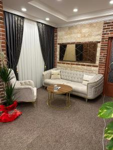 a living room with two couches and a brick wall at Konak Otel Suriçi in Diyarbakır