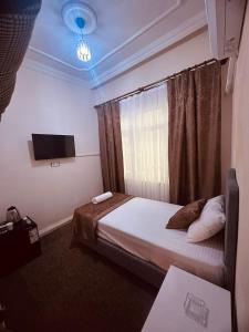 a bedroom with a bed with a tv and a window at Konak Otel Suriçi in Diyarbakır