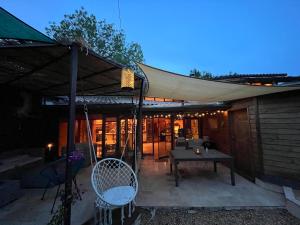 eine Terrasse mit einem Zelt, einem Tisch und Stühlen in der Unterkunft Maison d'architecte en bois lac au bord du lac Salagou in Celles