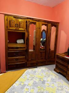 a large wooden cabinet with a mirror in a room at Cocklestop Inn, Jamaica in Pond Side