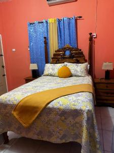 a bedroom with a large bed with blue curtains at Cocklestop Inn, Jamaica in Pond Side