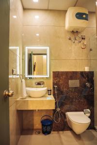 a bathroom with a sink and a toilet and a mirror at Anirudh Homestay in Agra