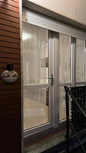 a glass door with white curtains in a room at Civico 32 in Montalto Dora