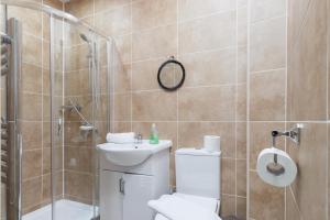 a bathroom with a shower and a toilet and a sink at Central 2 Bed flat in City Centre with Ensuites and Workspaces in Coventry