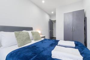 a bedroom with a blue and white bed with pillows at Central 2 Bed flat in City Centre with Ensuites and Workspaces in Coventry