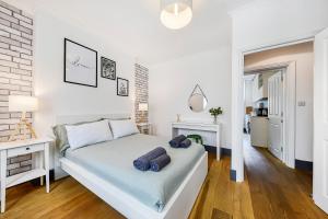 - une chambre blanche avec un lit et une cheminée dans l'établissement Modern one bedroom in Fitzrovia, Central London, à Londres