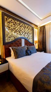 um quarto com uma cama grande e uma grande cabeceira. em Can Adalya Palace Hotel em Antália