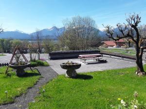 um parque com dois bancos e uma mesa de piquenique em Ferienwohnung Bergfeuer im Ferienhaus Weber em Füssen