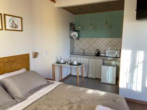 a bedroom with a bed and a small kitchen at Pouso Lumiar in Lavras Novas +15 photos