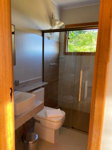 a bathroom with a toilet and a sink and a shower at Pouso Lumiar in Lavras Novas