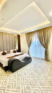 a bedroom with two beds and a large window at بالم السكنية in Abha
