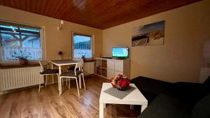 a living room with a table and chairs and a television at Bungalow zur Kühlung in Kühlungsborn