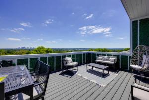 a deck with chairs and tables on a balcony at Luxury four-story Home, Rooftop Deck with views, PingPong! Sleeps 12! in Nashville