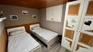 Cette petite chambre comprend 2 lits et une armoire. dans l'établissement Bungalow zur Kühlung, à Kühlungsborn