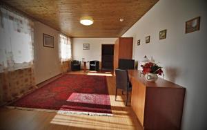 a living room with a desk and a red rug at Penzion Šejby in Horní Stropnice