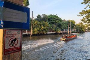 a boat on a river with people in it at Foodie Heaven in Thonhuri