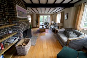 a living room with a couch and a fireplace at Picturesque 4 Bed Cottage Lingfield, Surrey in Felbridge
