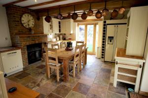 a kitchen with a table and a clock on the wall at Picturesque 4 Bed Cottage Lingfield, Surrey in Felbridge