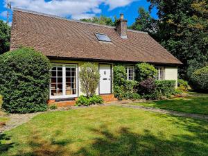 a house with a white door and a yard at Picturesque 4 Bed Cottage Lingfield, Surrey in Felbridge