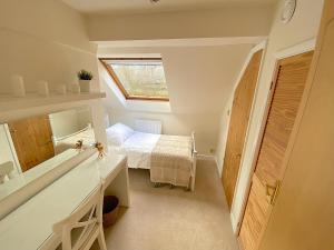 a bathroom with a sink and a bed in a room at Picturesque 4 Bed Cottage Lingfield, Surrey in Felbridge