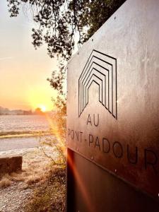 un signo de anoint parkland con la puesta de sol en el fondo en Des vacances au Pontpadour !, en Entraigues-sur-la-Sorgue