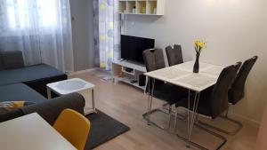 un soggiorno con tavolo, sedie e TV di Apartment Verdi Split a Spalato (Split)