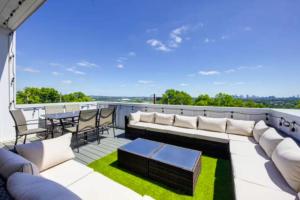 a patio with a couch and a table on a roof at Luxury four-story Home with Rooftop views, 10min to Downtown! Sleeps 12! in Nashville