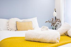 - une chambre avec un lit blanc et un tapis jaune dans l'établissement Luxury 1 BR Near Westfield Stratford - 10 Min Walk, à Londres