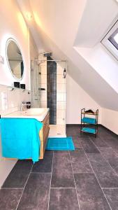 La salle de bains est pourvue d'une baignoire bleue et d'un lavabo. dans l'établissement Ferienwohnungen An den SchwabachAuen - Keine Monteure, à Eckental