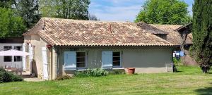 ein kleines weißes Haus mit einem Rasenhof in der Unterkunft Gîte La Fournière de Costy in Agnac