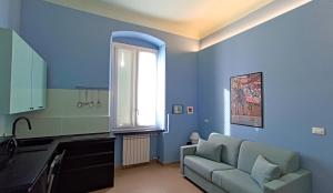 a blue living room with a couch and a window at LE VOCI DELLA FONTANA in La Spezia