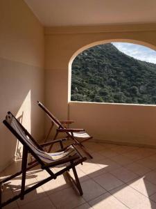 twee stoelen in een kamer met een open raam bij Vill'e Tina in Torre delle Stelle