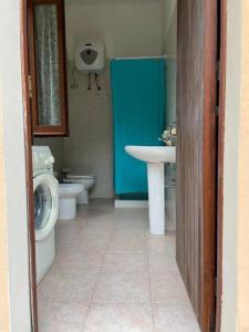 een badkamer met een wastafel, een toilet en een wastafel bij Vill'e Tina in Torre delle Stelle