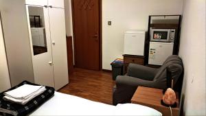Airbnb Ferentella في تريفيزو: غرفة بسرير وكرسي ومطبخ