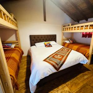 1 dormitorio con 2 literas en una habitación en Casa Museo - Naturaleza y Tradición, en Otavalo