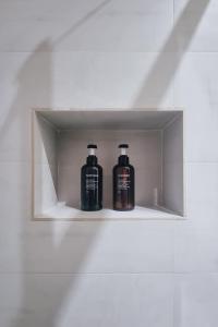 two bottles ofodorizers sitting on a shelf in a bathroom at Ugo's Urban Home: Porta Nuova District in Milan