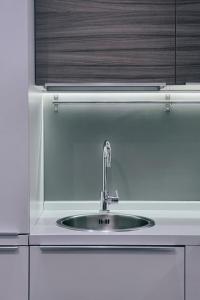um lavatório numa cozinha com um balcão branco em Ugo's Urban Home: Porta Nuova District em Milão