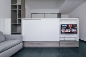 a living room with a couch and a white wall at Ugo's Urban Home: Porta Nuova District in Milan