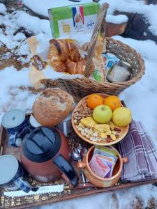 um piquenique com pão e frutas e uma chaleira em Petit Chalet Nature em Les Rousses