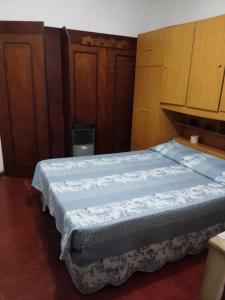 a bedroom with a bed and wooden cabinets at "Mi pequeño refugio" - Apartamento Colonia del Sacramento in Colonia del Sacramento