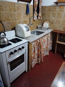 a kitchen with a stove and a sink at "Mi pequeño refugio" - Apartamento Colonia del Sacramento in Colonia del Sacramento