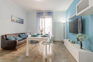 ein Wohnzimmer mit einem Tisch und einem Sofa in der Unterkunft H11 [House of Colors] Parcheggio in Taggia