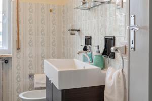 a bathroom with a white sink and a toilet at H11 [House of Colors] Parcheggio in Taggia +23 photos
