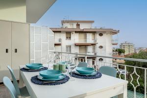 a balcony with a table and chairs and a building at H11 [House of Colors] Parcheggio in Taggia