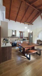 a large kitchen with a wooden table in a room at Anasa Residence - The Farm house in Varípetron